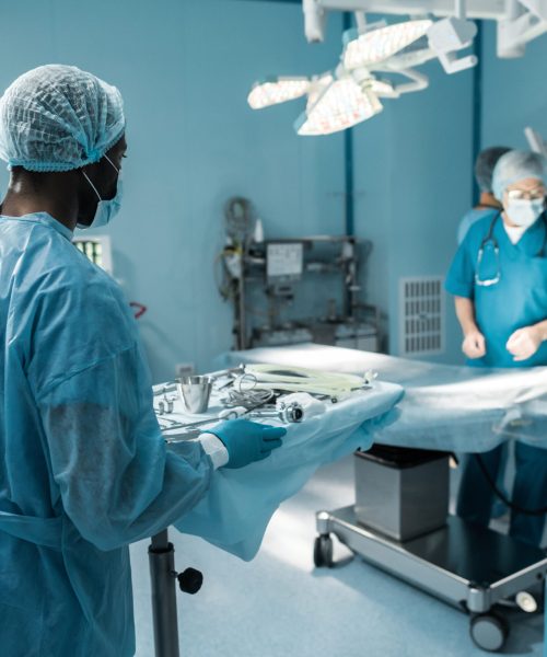 african american doctor holding tray with medical tools for surgery