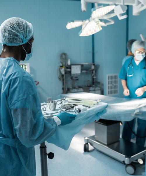 african american doctor holding tray with medical tools for surgery
